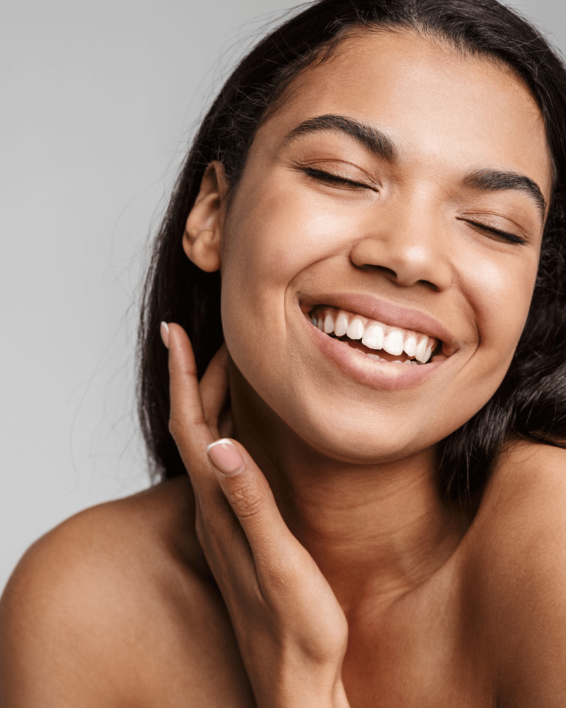 Radiant woman smiling with healthy glowing skin — a symbol of skin confidence and intentional skincare.