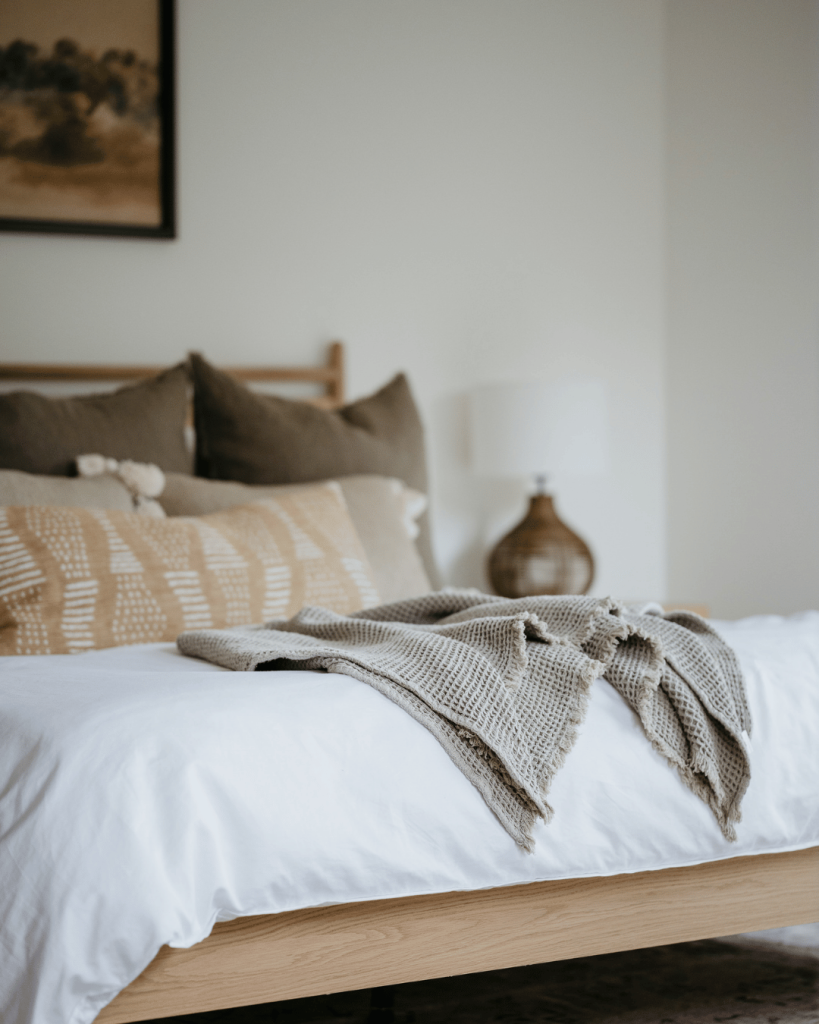 Cozy neutral-toned bedroom with layered textures — aligning with the intentional living and relaxation themes of self-care.